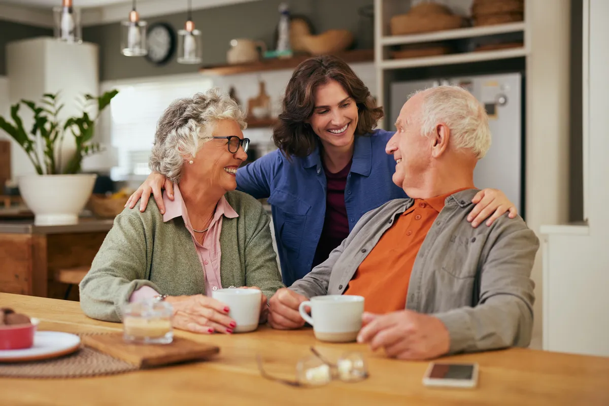 Conversations That Heal - Senior woman smiling and engaging in conversation with parents in a memory care.
