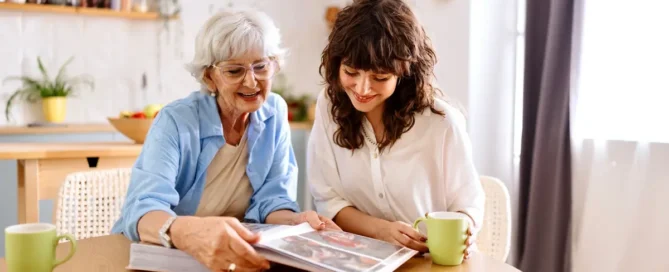 Senior woman and grandchild looking at old photo album together representing memory care services and family involvement in Medford Oregon