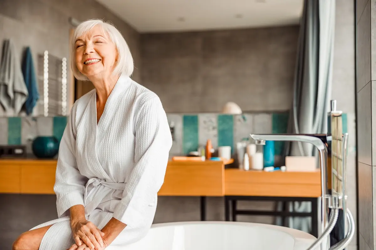 What stage of dementia is not bathing: senior woman in bathrobe sits in bathroom