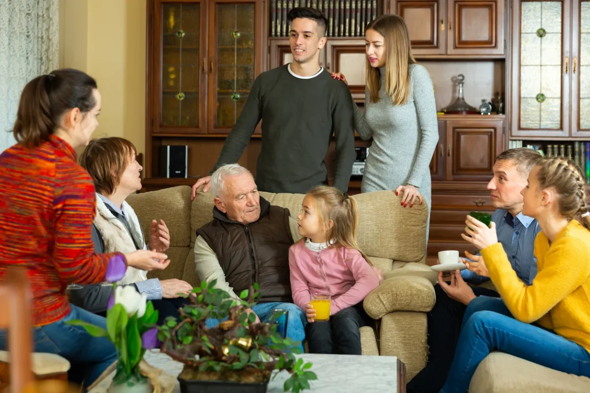 Large family spending time together at home, representing a family meeting memory care conversation about support, planning, and next steps.